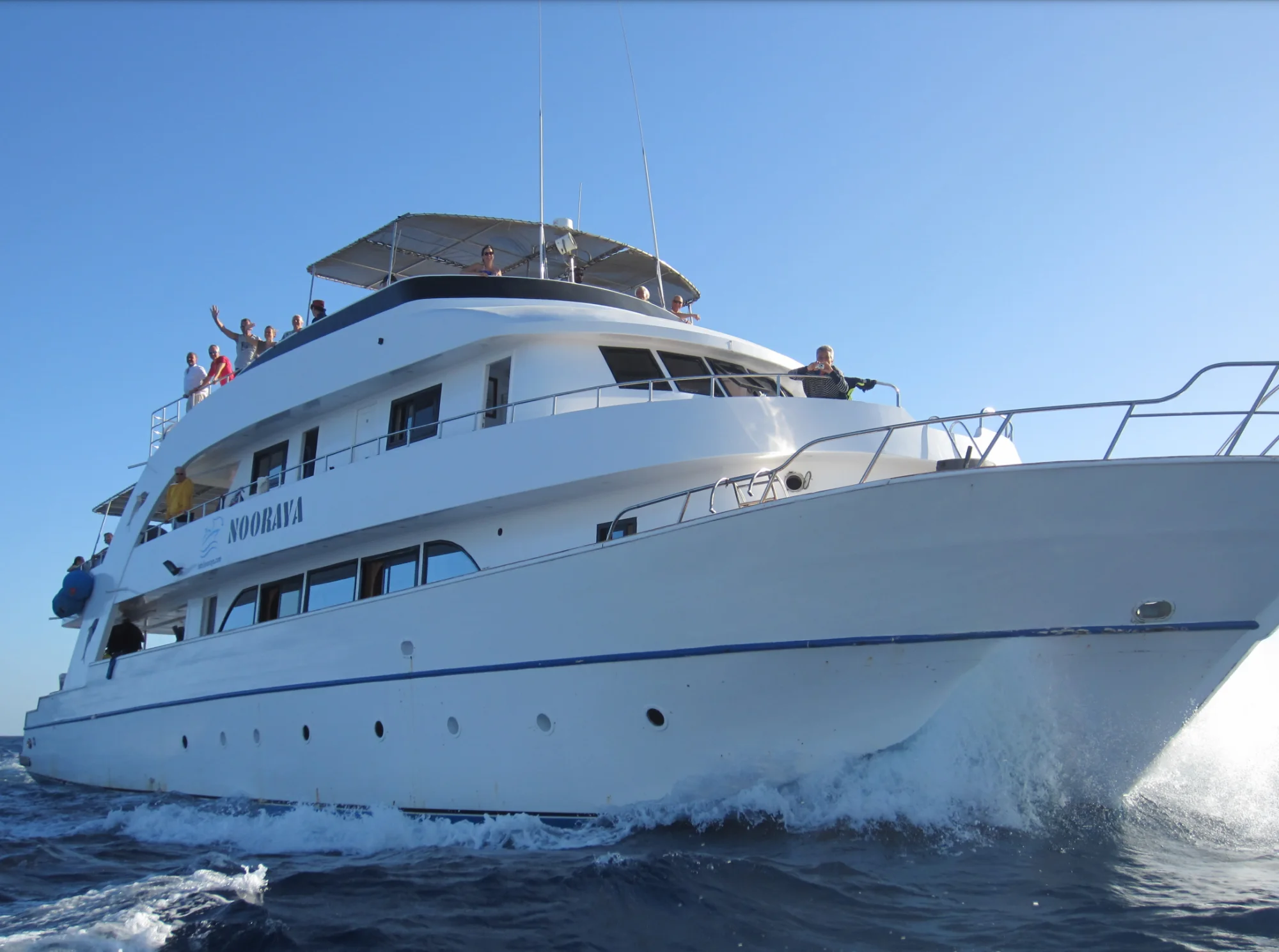 The Nooraya under way, guests waving from the deck